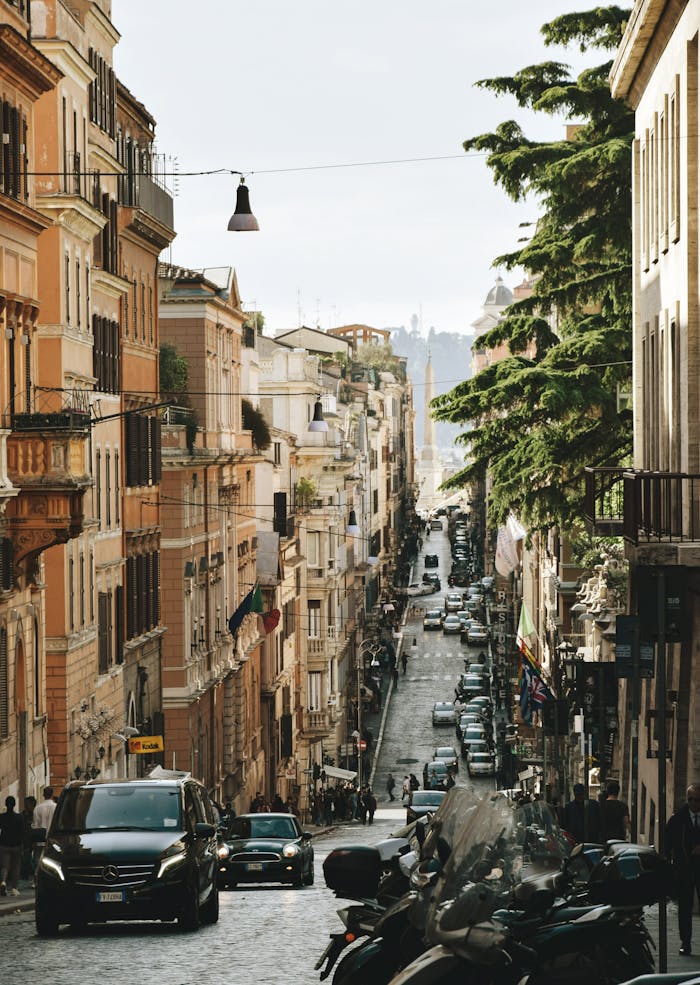 A vibrant urban street in Rome, Italy, lined with buildings and moving vehicles. Captures the essence of city life.